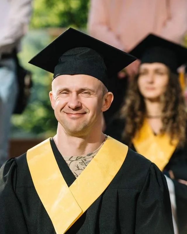 Випускник SET University у мантії та академічній шапці