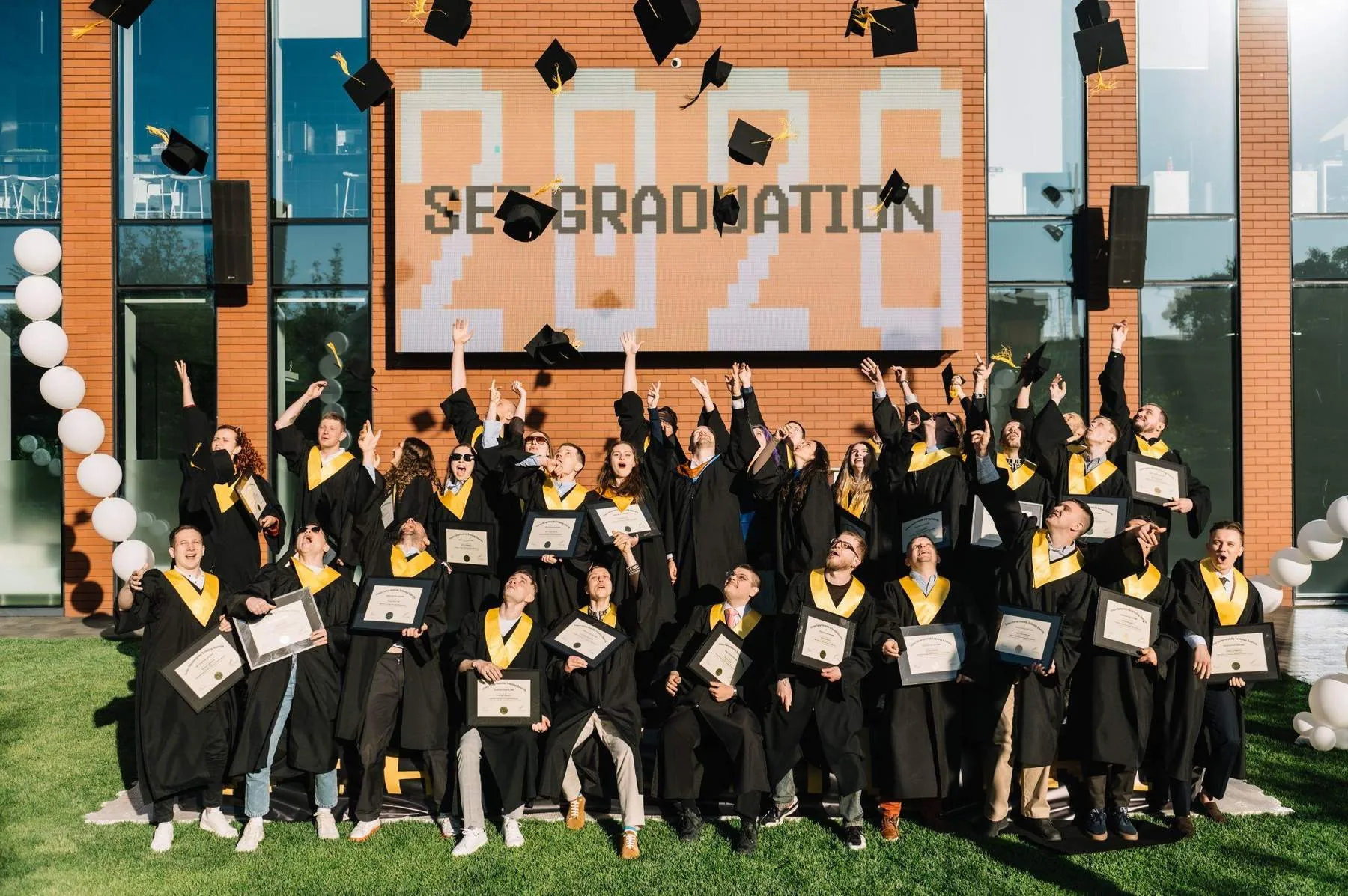 Випускники SET University підкидають академічні шапки на випуску 2026 року в Києві