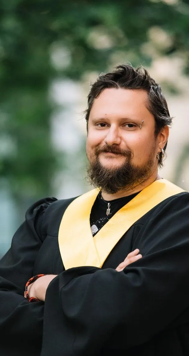 Випускник SET University зі схрещеними руками