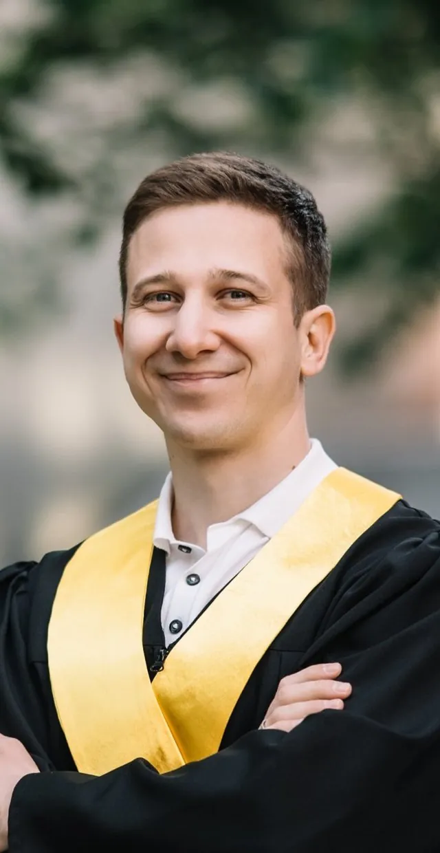 Усміхнений випускник SET University зі схрещеними руками